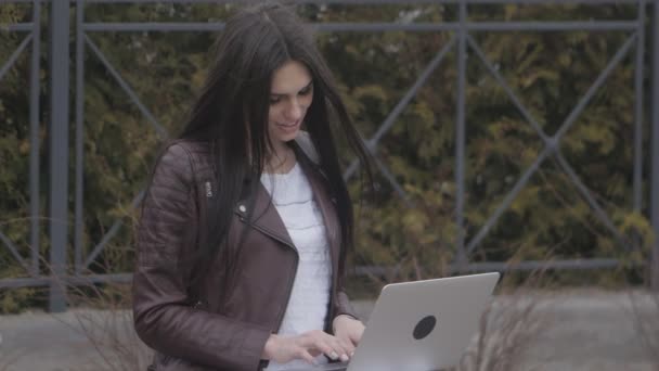 Крупный план молодой привлекательной предпринимательницы, использующей ноутбук на открытом воздухе — стоковое видео