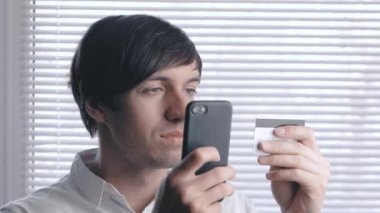 Online Kredi kartı ile alışveriş smartphone kullanan adam