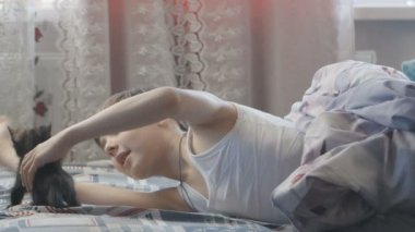 Çocuk yavru kedi ile yatak odasında yatağında oynuyor. Mutlu çocukluk