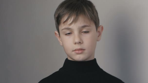 Портрет маленького мальчика 10 лет в черном свитере, смотрящего в камеру — стоковое видео