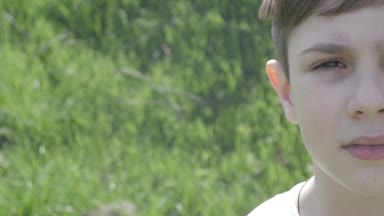 Portre yarı-yüz bir çocuğun 10 yaşında yeşil çim bir arka plan üzerinde kapatın