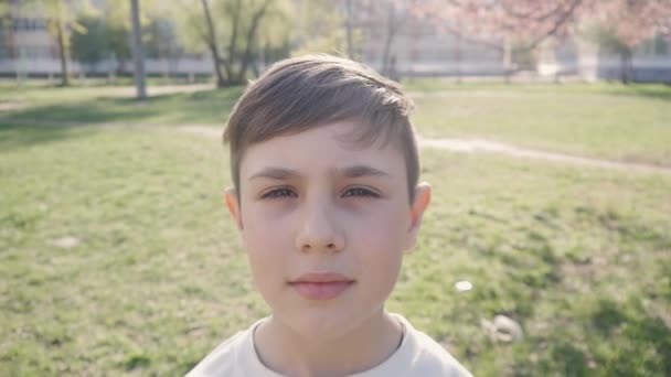 Retrato de menino de 10 anos em um fundo de vegetação na primavera ou verão . — Vídeo de Stock