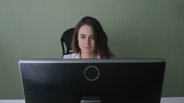 Портрет бізнес-леді в білій сорочці, що працює за комп'ютером в офісі — стокове відео