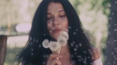 Kadın üfleme bir karahindiba slowmotion içinde üzerinde