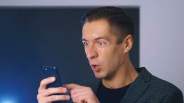 Genç adam Smartphone 'da mesaj okurken başarıyı kutluyor. Yakışıklı profesyonel başarılı iş adamı kişisel hedeflerine ulaşıyor.
