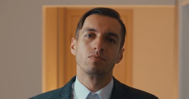 Portret van een jonge zelfverzekerde zakenman die naar de camera kijkt. Close-up van serieuze mannelijke teamleider in een pak — Stockvideo