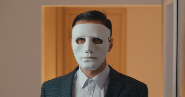 Portret van een jonge zakenman die zijn gezicht verbergt met een masker. — Stockvideo