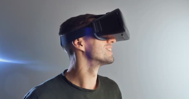 Egy fiatal férfi virtuális valóság technológiát visel Vr Szemüveg. Ember meglepett kiterjesztett valóság virtuális valóság sisak fehér alapon — Stock videók