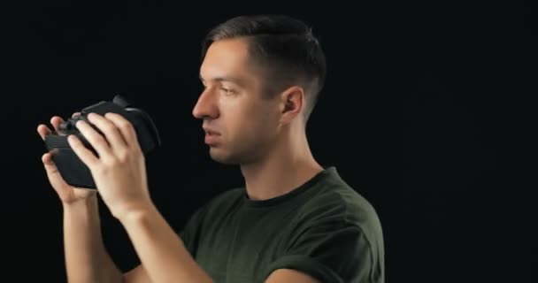 Gire a Young Man probando gafas VR sobre fondo negro. Masculino geting sorpresa usando Realidad Virtual Casco 3D Juegos Innovación Internet Entretenimiento Tecnología — Vídeos de Stock