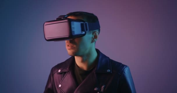 Hombre Virtual Reality Console Auriculares Sorprendidos Diversión Videojuego en las luces de neón multicolor de moda. Hombre usando gafas VR . — Vídeos de Stock