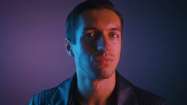 Retrato de macho em luz de néon multicolorida. Retrato de jovem à noite durante a festa em luzes de néon . — Vídeo de Stock