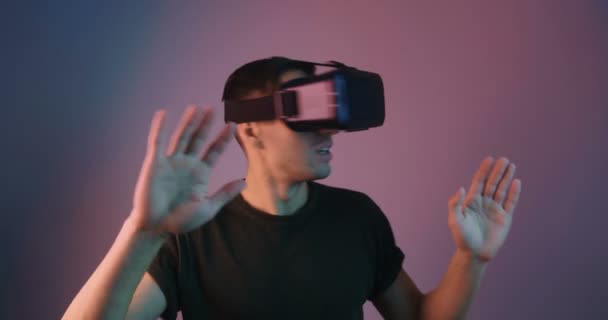 Retrato de homem usando VR Glassess em luz de néon multicolorida. Jovem em capacete realidade virtual em luzes de néon futuristas . — Vídeo de Stock