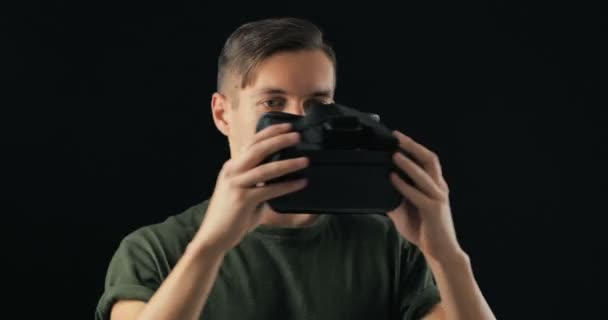 Young man looking virtual reality technology VR Glasses. The guy is surprised and delighted using virtual reality glasses — Stock Video