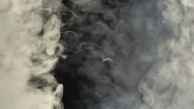 Gerçekçi Duman Bulutları çerçevenin içinden uçuyor. Efektler ve geçişler için iyi bir görüntü. Siyah izole arkaplanda duman bulutu