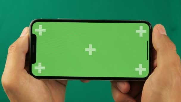 Gros plan des mains masculines touchant le smartphone. Écran vert Chroma Key. L'écran du téléphone est une clé chromatique verte, arrière-plan avec un autre écran vert chromatique. Images pour les annonces mobiles, app promo . — Video