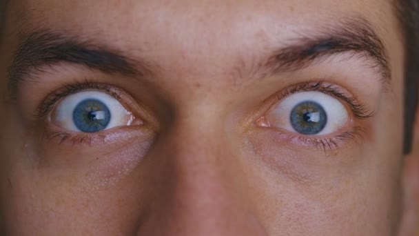 Крупный план макро красивые мужчины голубые глаза изображают страх и удивление — стоковое видео