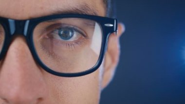 Gözlüklü bir adamın makro mavi gözü. İş adamının ya da gözlüklü öğrencinin gözlerini kapat.
