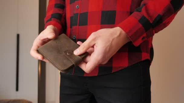 お金がないから人は怒っている。お金のない空の革の財布を示す男性の手のクローズアップ。金融事業破産の概念. — ストック動画