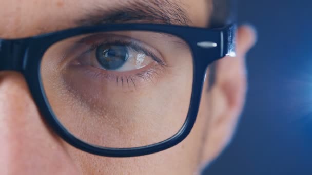 Macro ojo azul del hombre con anteojos. Primer plano ojo de hombre de negocios o estudiante en gafas — Vídeos de Stock