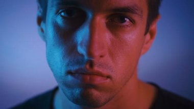 Çok renkli neon ışıklı bir erkeğin yakın plan portresi. Gece partide neon ışıklarda genç bir adamın portresi..