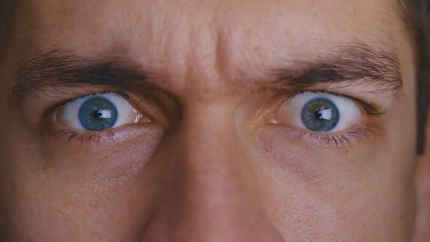 Nahaufnahme der Augen. der Mann ist wütend und runzelt die Stirn — Stockvideo