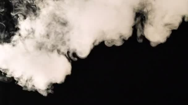 Smoke flies through the frame on a black background. Good footage for effects and transitions. — Stock Video