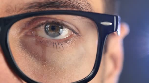 Macro ojo azul del hombre con anteojos. Primer plano ojo de hombre de negocios o estudiante en gafas — Vídeos de Stock