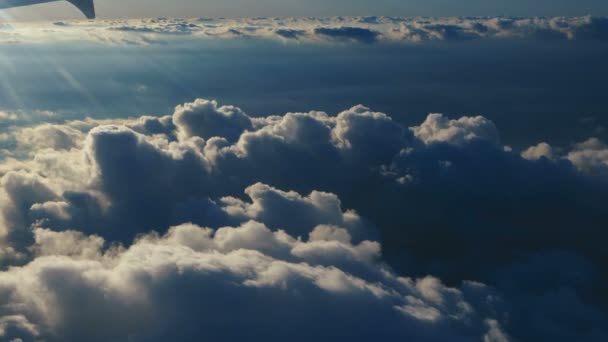 Flygfoto ovanför moln från flygplansfönstret med blå himmel. utsikt från flygplansfönstret till den blå himlen och vita moln. Flygresor. — Stockvideo