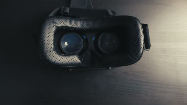 Detailní záběr brýlí virtuální reality Vr hemlet ležících na černém stole. Koncept moderních technologií. — Stock video