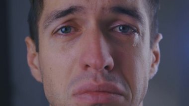 Gözyaşları içinde ağlayan üzgün bir adamın yakın çekimi.