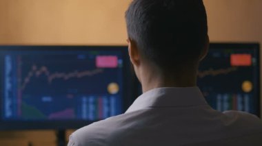 Hisse senedi almadan veya satmadan önce bilgisayardaki grafikleri analiz eden genç komisyoncu işadamlarının arka planı