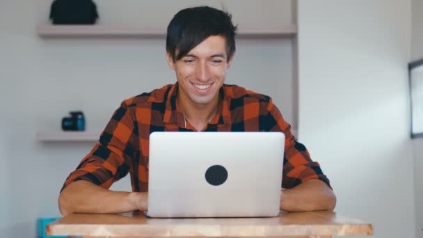 Retrato del apuesto hombre sonriente Freelancer Trabajando en el ordenador portátil, sentado en el escritorio en casa . — Vídeo de stock