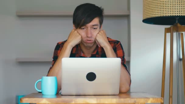 Trieste man freelancer met behulp van laptop online werken vanuit huis in internet voelen frustratie. Portret shot van trieste wanhopige man huilen tijdens zijn werk op de laptop. — Stockvideo
