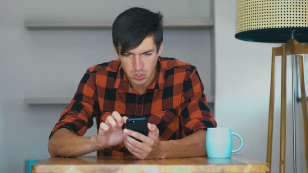 Dühös férfi mobiltelefont használ otthon. Frusztrált vállalkozó dühös az üzenetet, hogy ő olvasta az okostelefon. Stresszes üzletember használ okostelefon. — Stock videók