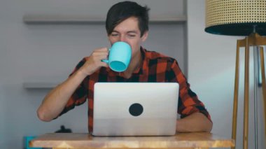 Business man freelancer working laptop computer and drinking coffee at home