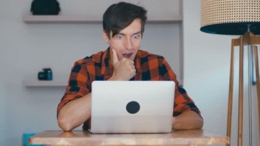 Overjoyed Excited Young Man Freelancer Looking At Laptop Celebrating Success Victory working at home