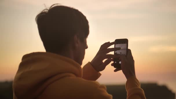 Мужчина турист делает фото на смартфоне красивый тропический пляж на закате. Концепция образа жизни и путешествий . — стоковое видео