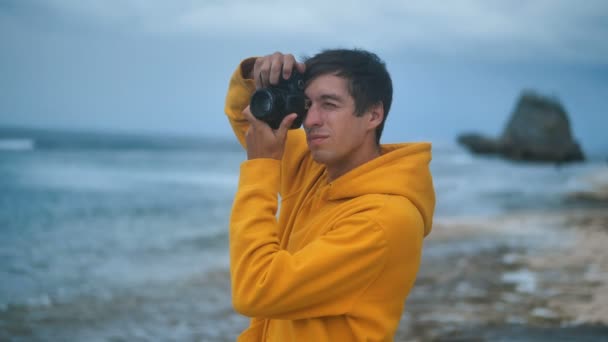 Giovane fotografo di avventura che scatta fotografie sulla bellissima spiaggia tropicale — Video Stock