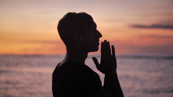 Силуэт человека, молящегося на закате, концепция религии. Силуэт человека близко . — стоковое видео