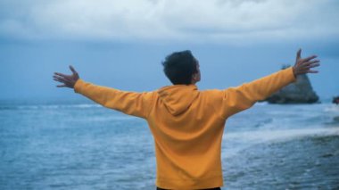 İnsan gezgin, akşamları güzel tropikal plajda ayakta el kaldırır. Özgürlük kavramı