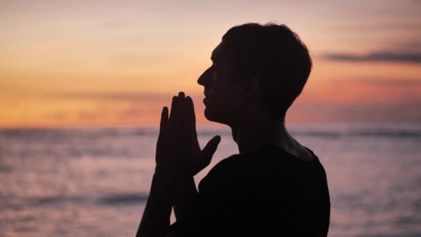 Silhouette di un uomo che prega al tramonto concetto di religione. Silhouette uomo vicino . — Video Stock