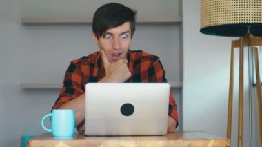 Overjoyed Young Man using Laptop Excited by Online Win