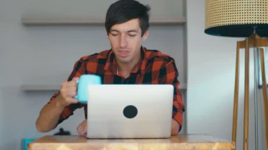 Evde dizüstü bilgisayarın önünde iyi sonuçlar alan serbest çalışan genç adam şaşırdı..