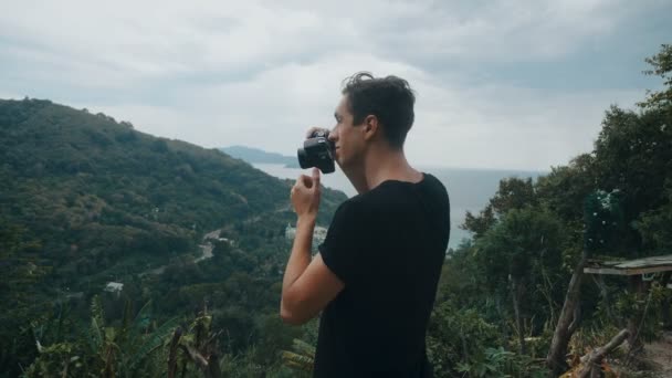 Traveler photographing in mountain shooting picturesque views. Man tourist takes photo on camera outdoors. Professional photographer traveler. — Stock Video