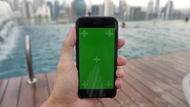 Primo piano di smartphone con chiave cromatica Green Screen che riposa vicino alla piscina, guardando video su touch screen con Tracking Markers. Utilizzo del telefono in vacanza — Video Stock