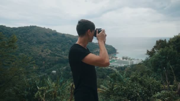 Traveler photographing in mountain shooting picturesque views. Man tourist takes photo on camera outdoors. Professional photographer traveler. — Stock Video