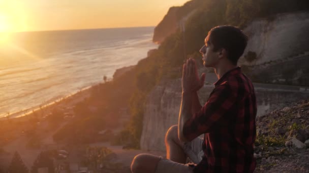 Η σιλουέτα ενός άντρα που προσεύχεται στο ηλιοβασίλεμα, έννοια της θρησκείας. Ο άνθρωπος σιλουέτα κοντά. — Αρχείο Βίντεο