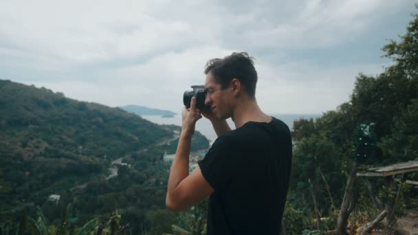Homem viajante fotografar em montanha fotografar vistas pitorescas. Fotógrafo profissional viajante tira foto na câmera ao ar livre . — Vídeo de Stock