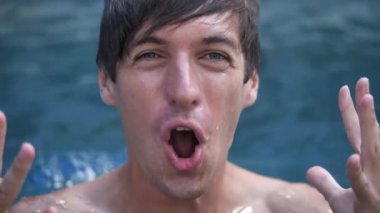 Şok Olan Genç Adam Yüzme Havuzu Tatilinde Kazanan Hareketi Gösteriyor. Atlet yüzücü zafere seviniyor.
