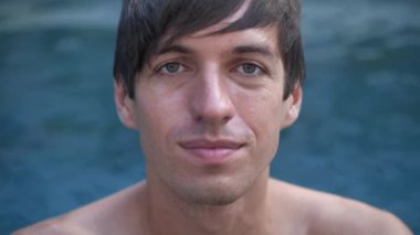 Genç bir adamın yakın plan portresi havuzda keyif çatıyor.